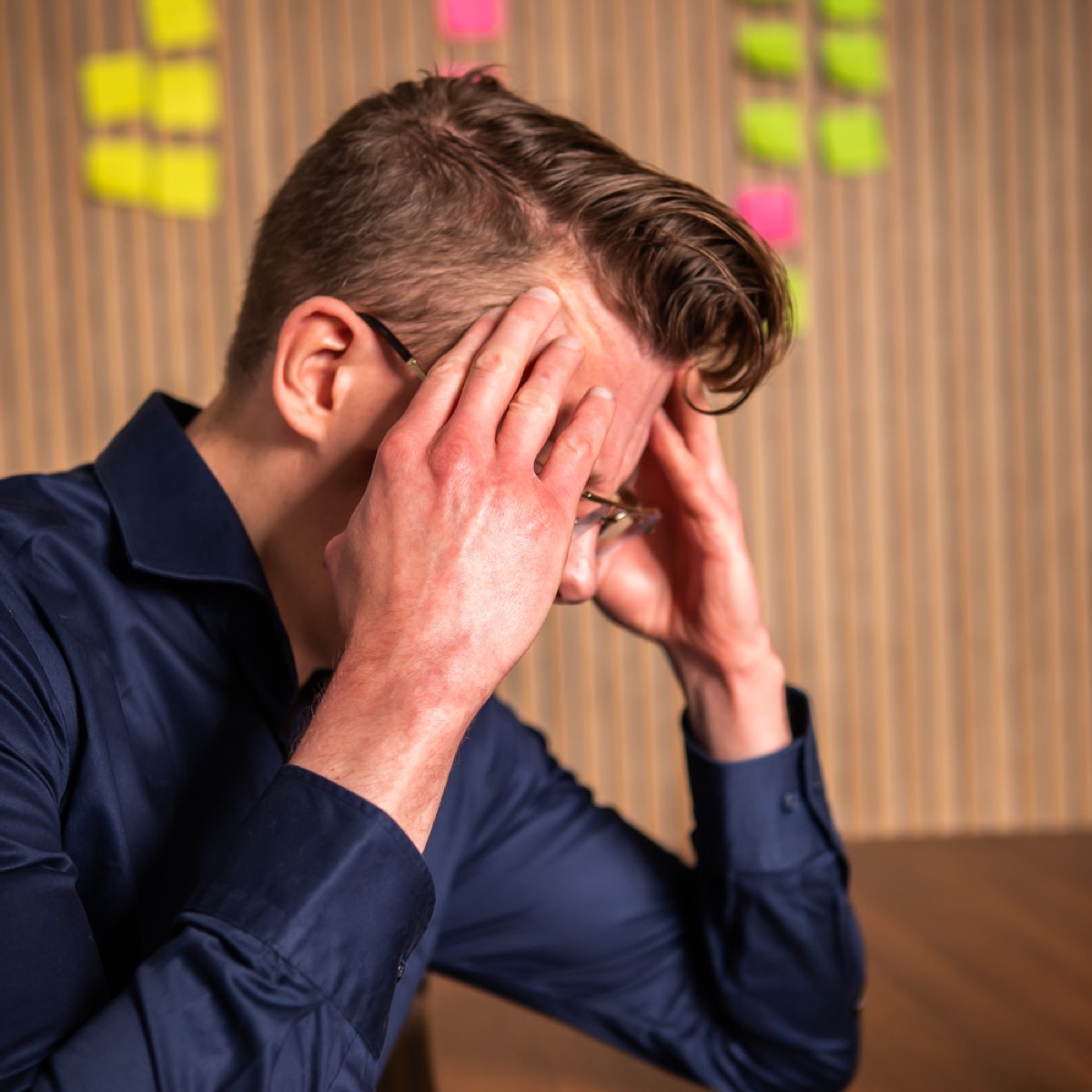 Man met hoofdpijn achter zijn laptop